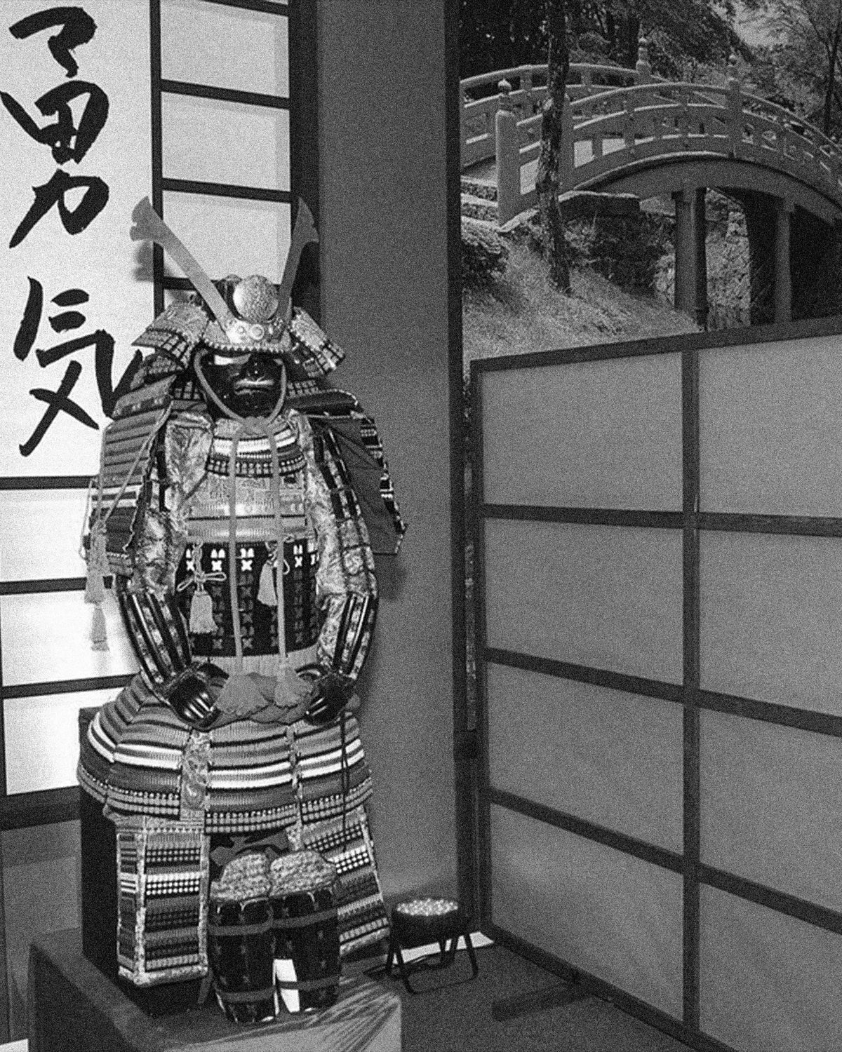 Samurai armour on display beside the calligraphy 勇気, courage